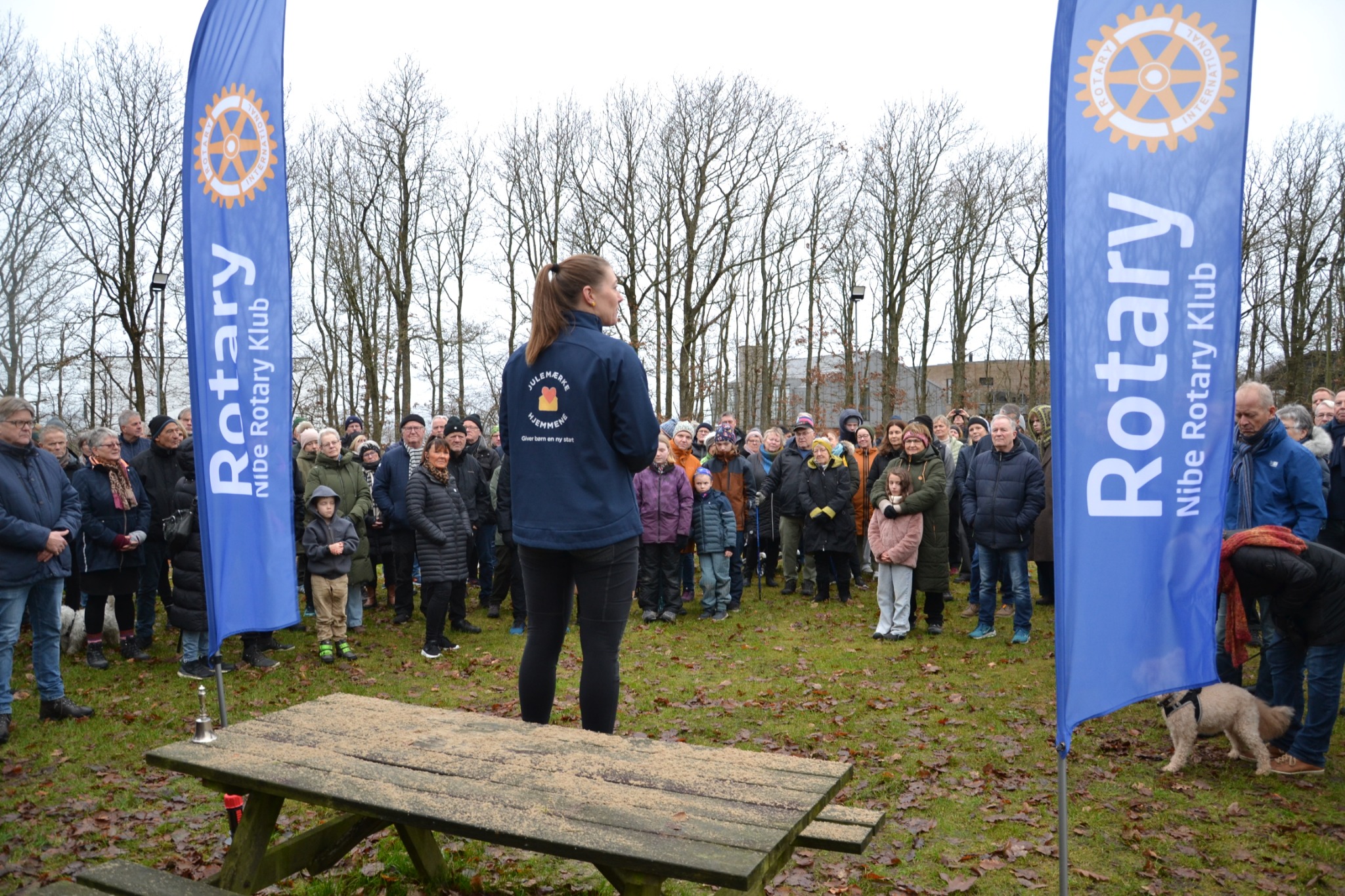 Rotary-arrangement med deltagere samlet mellem Rotary-flag